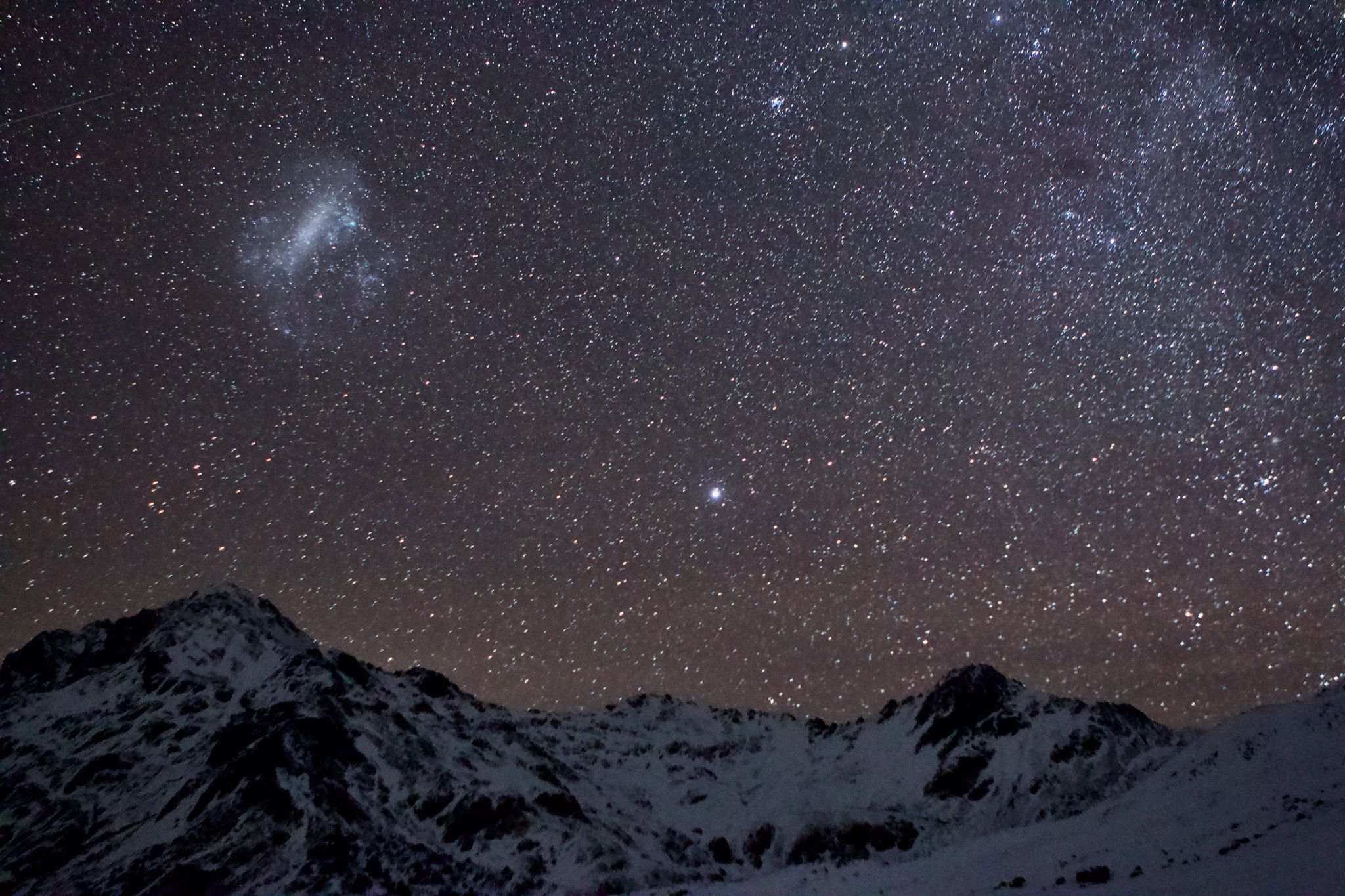 The Large Magellanic Cloud over Maniniaro/Angelus Peak, and the star Canopus glowing brightly to the right of Sunset Saddle.